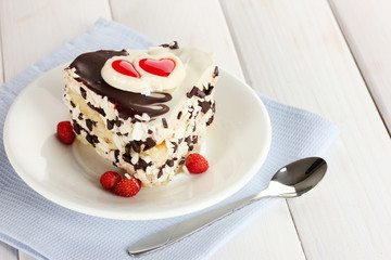 sweet cake with chocolate on plate on wooden table