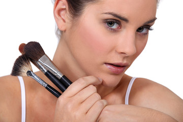 Woman with a selection of makeup brushes