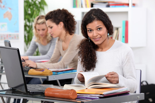 Adult student working at a laptop in a classroom