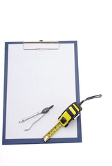compasses and a measuring tape on a clipboard