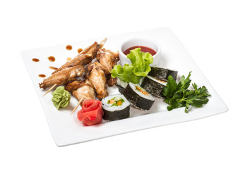 Buffalo chicken wings on plate with sushi
