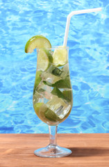 cold fresh lemonade on wooden table on sea background