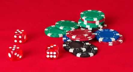 Poker chips wirh dice on a red table