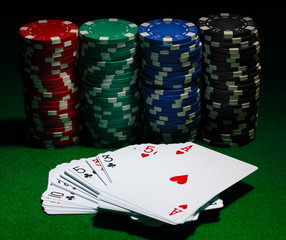Cards and chips for poker on green table