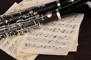 Musical notes and clarinet on wooden table