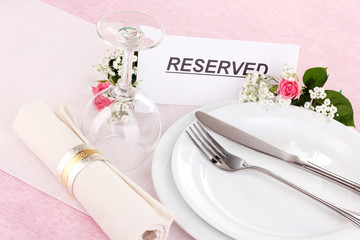 Table setting with reserved card in restaurant