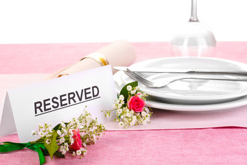 Table setting with reserved card in restaurant