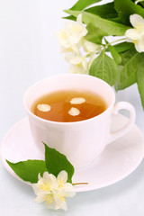 Fototapeta na wymiar Tasty jasmine tea and beautiful flowers