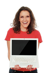 A smiling woman showing a screen of a laptop, isolated on white