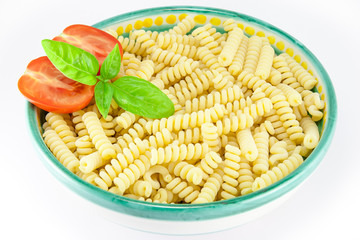 Bowl full of fusilli pasta with tomatoes and basil