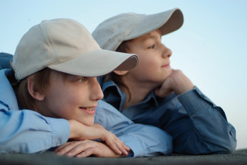 Two Caucasian brother sitting in the caps