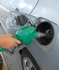 A man pumping gas in to the tank