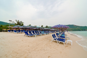 Beach chairs with umbrella on the white sand beach