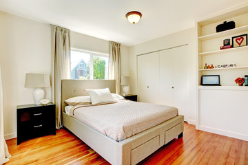 White bedroom with hardwood cherry floor.
