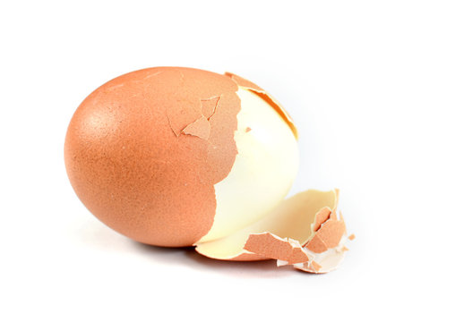 Hard Boiled Egg With Scale Coming Of Over A White Background