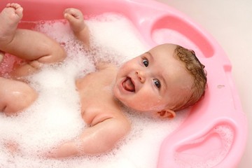 Pretty baby in the bath with foam