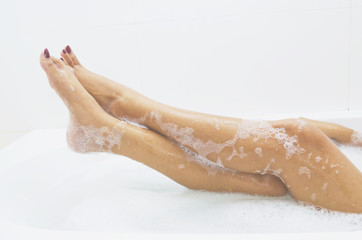 Woman is covered with a foam bath  She is taking a bath  She is