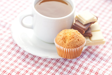 bar of chocolate,tea and muffin on plaid fabric