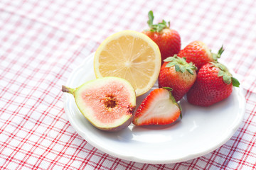 lemon, fig and strawberries on a plate - Powered by Adobe