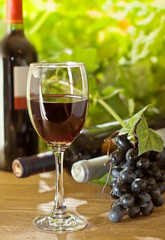 Red wine and grape on the wooden table, outdoor