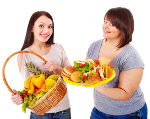 Women choosing between fruit and hamburger.