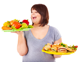 Woman choosing between fruit and hamburger.