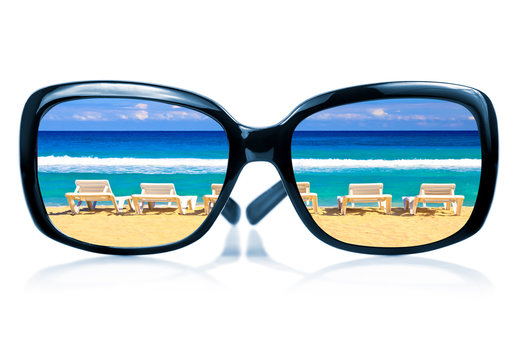 Sunglasses with a tropical beach reflected on them