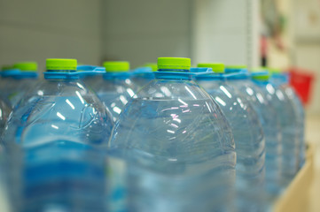 Bottles with fresh water on shelves in supermarket
