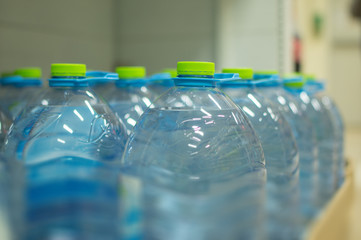 Bottles with fresh water on shelves in supermarket