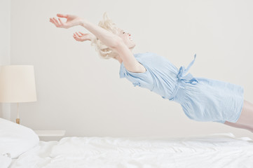 Fototapeta Junge Frau springt ins Bett obraz