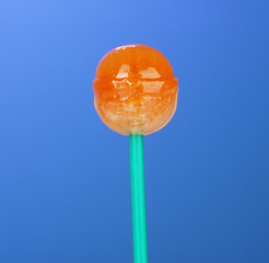 Sweet and tasty lollipop on bright blue background close-up
