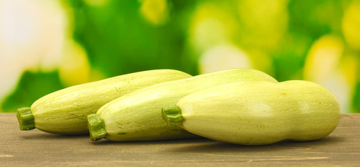 squash on wooden table on green background close-up