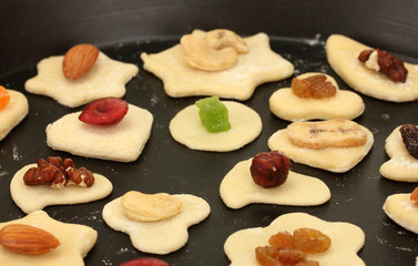 unbaked cookies with candied fruits and nuts in a pan close-up