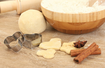 Cookie cutter with rolling pin on wooden table close-up