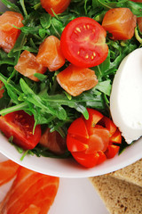 salad with smoked salmon in white bowl