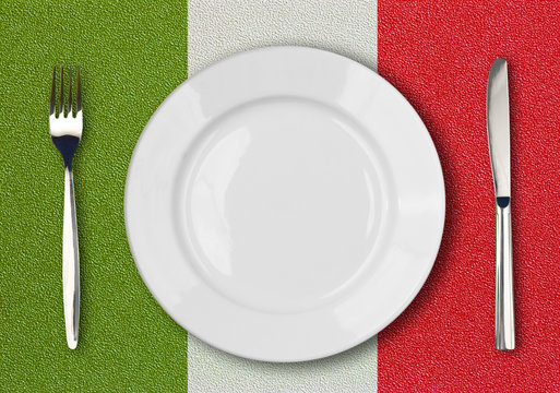 White plate, fork and knife top view on italian flag plastic tab