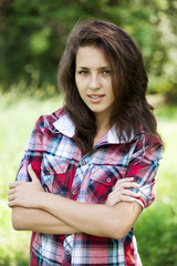 Naklejka premium Beautiful teen girl in the park at green grass.
