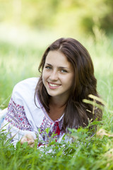 Naklejka na ściany i meble Slav teen girl at green meadow in national ukrainian clothing.