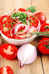 tomato salad in white bowl with bundle of chives