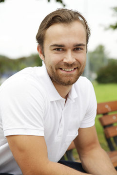 Sportlicher junger Mann auf Parkbank