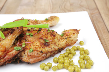 chicken garnished with green sweet peas and red hot pepper