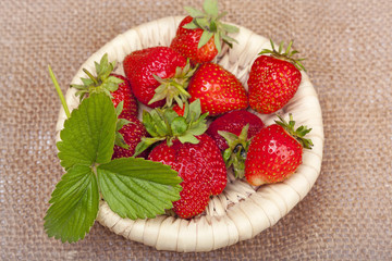 strawberries with leaves in a wicker basket