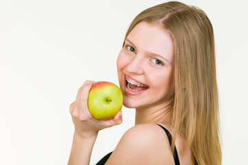 Beautiful Young woman with brackets eating apple