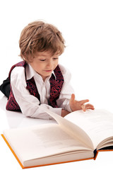 Preschooler reading a book while lying on the floor