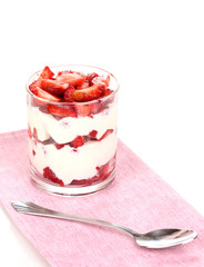 Glass of ripe strawberries with cream isolated on white