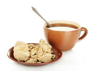 A cup of tea and saucer with delicious halva isolated on white