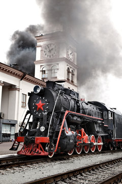 Old steam train is leaving a station © Sergii Figurnyi