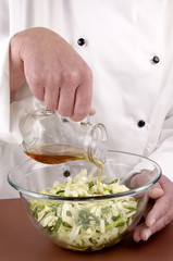 chef gives oil to chopped savoy cabbage