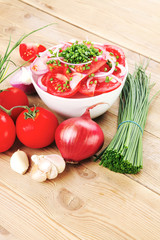 tomato salad in white bowl with bundle of chives