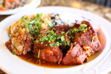 Cochinita pibil plate with pork served beans, and rice.
